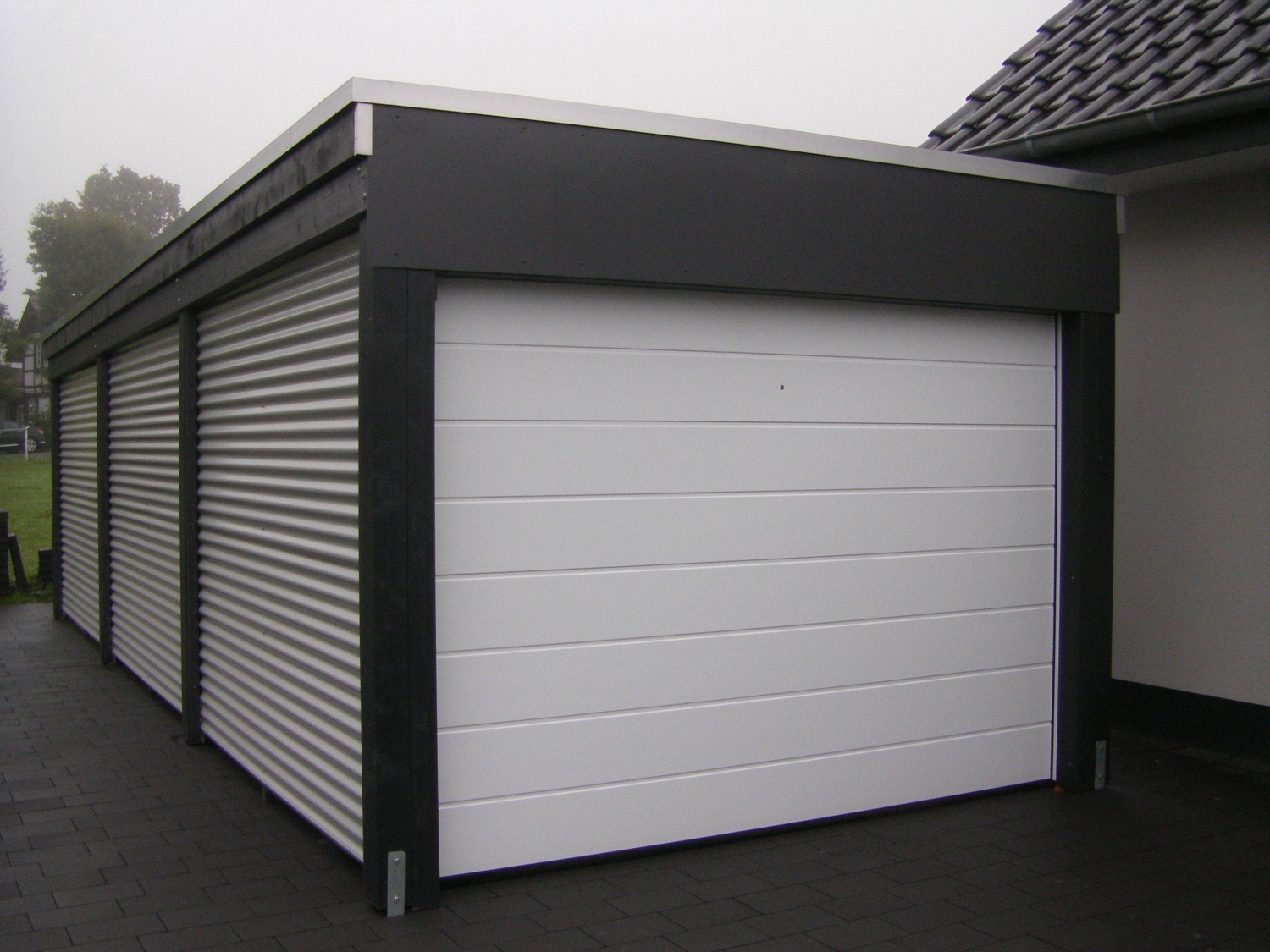 Ansprechender Carport mit Sektionaltor als Garage