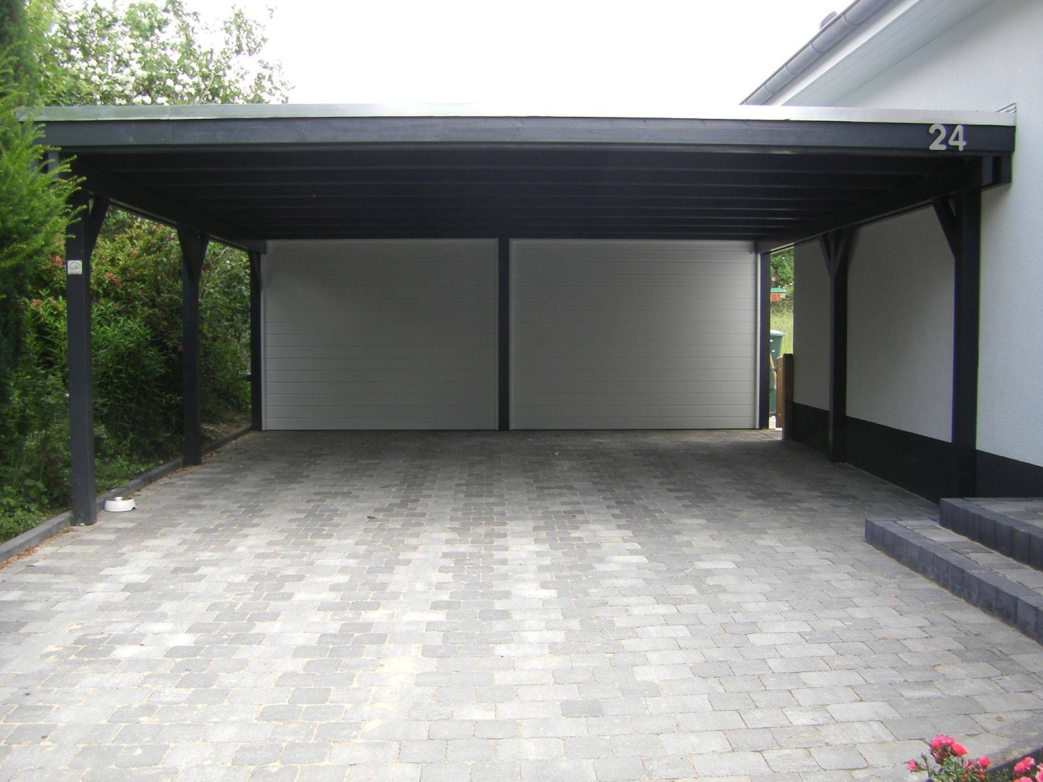 Großzügiger Carport mit weiß lackierter Rückwand
