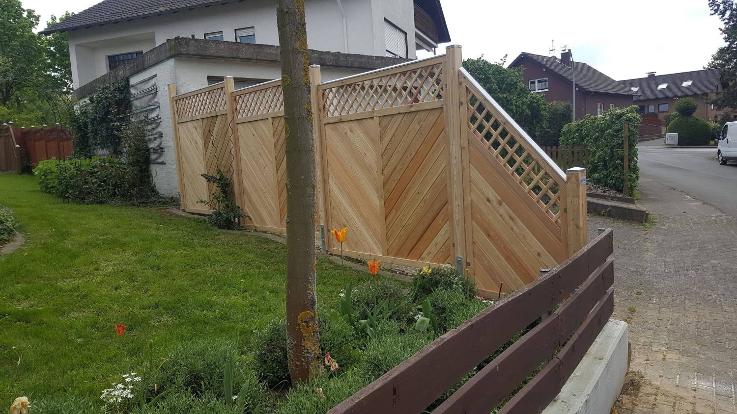 Zaun aus Lärche an Einfahrt mit Gefälle