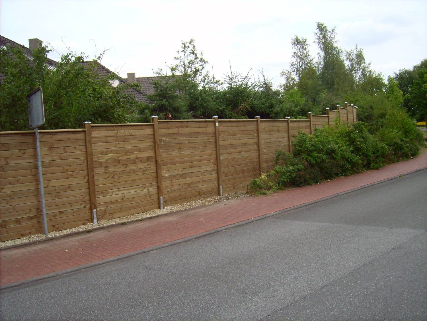 Klassischer Schallschutzzaun an verkehrsreicher Straße