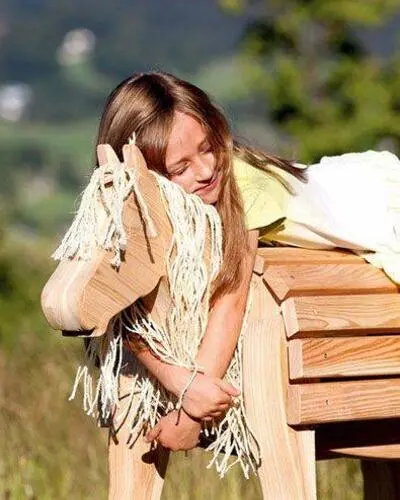 Mädchen auf Holzpferd, Gartenpferd für Kinder